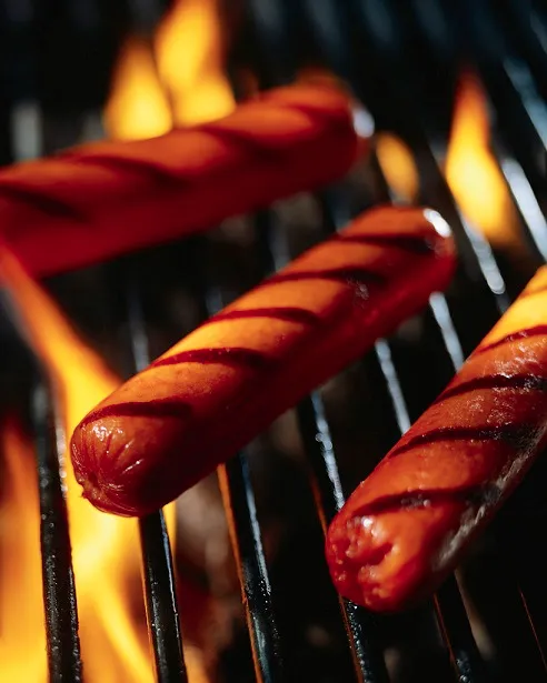 Hot dogs cooking on a grill